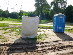 Anteparo construído para banho de trabalhador ao lado de banheiro químico em obra do Arraial da Lagoa