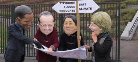 Em protesto, ativistas fantasiados de presidentes discutem caminho a seguir. A placa ao fundo, indica o caminho para furacões, enchentes e secas de um lado, e para segurança climática do outro. Foto: Divulgação/OXFAN