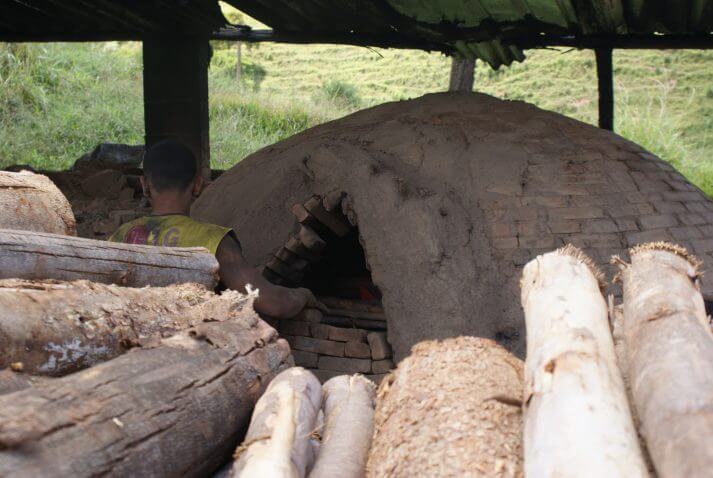 Trabalhador sem equipamento de proteção individual colocando madeira em forno de carvoaria flagrada com trabalho escravo em Piracaia (SP) (Foto: Stefano Wrobleski)