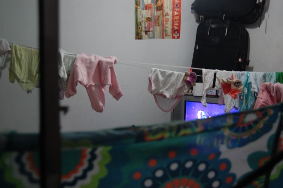 Dormitório com pano tapando parte da janela e com roupas penduradas em seu interior. Foto: Igor Ojeda