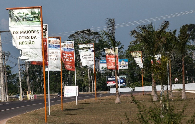 Placas e banners com propaganda imobiliária forram a estrada, na chegada à Iranduba. Foto: Lilo Clareto