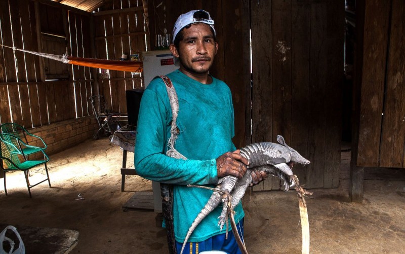 Beiradeiro mostra o tatu que caçou para alimentar o pai, a madrasta, a mulher e dois irmãos. Foto: Lilo Clareto/Repórter Brasil